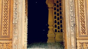 Un portal ornamentado con intrincados grabados y un interior oscuro.