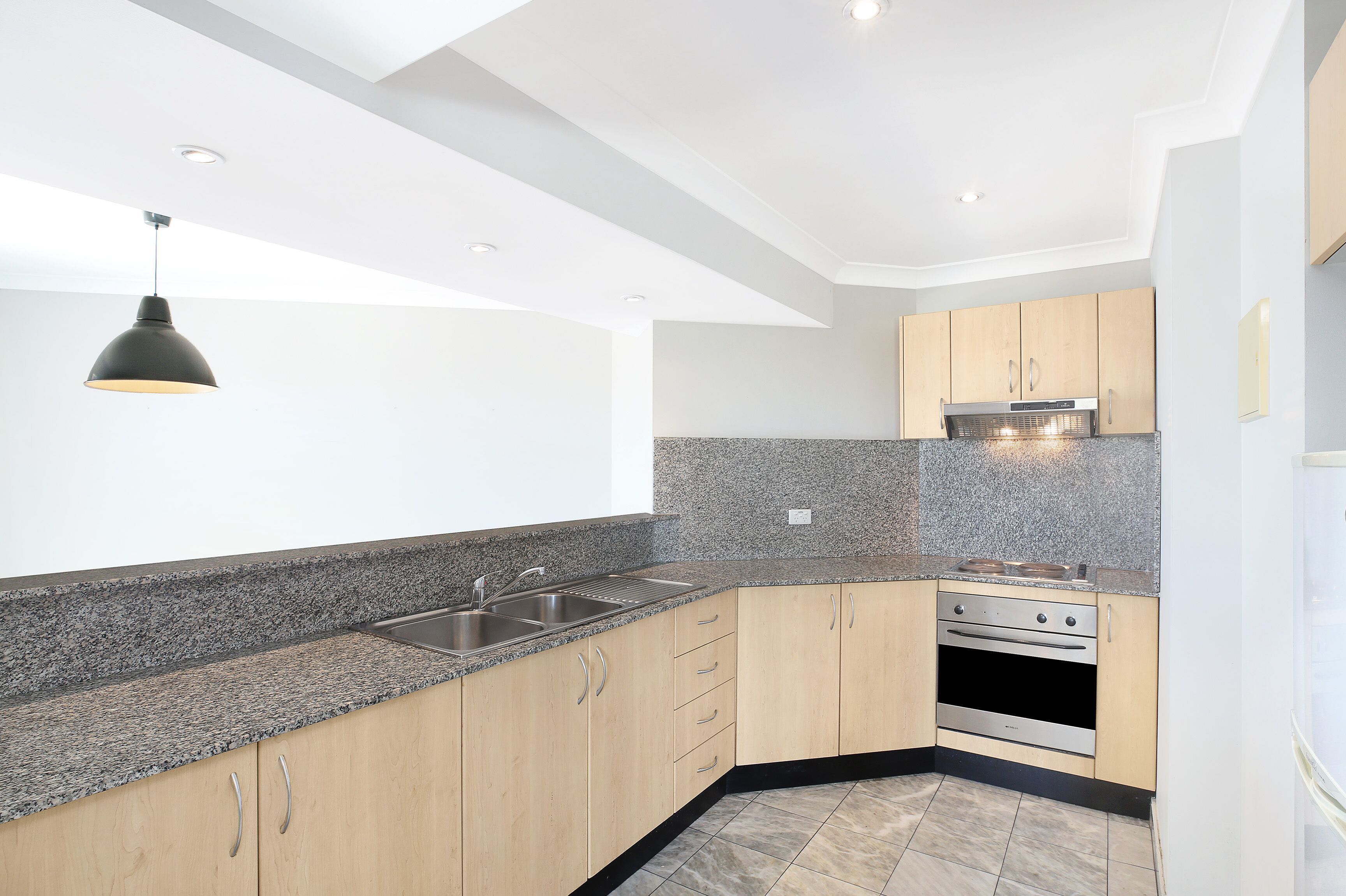 A modern kitchen with granite countertops, stainless steel appliances, and wooden cabinets.
