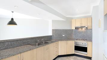 A modern kitchen with granite countertops, stainless steel appliances, and wooden cabinets.