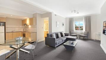 A modern apartment with a living room, dining area, and kitchen.