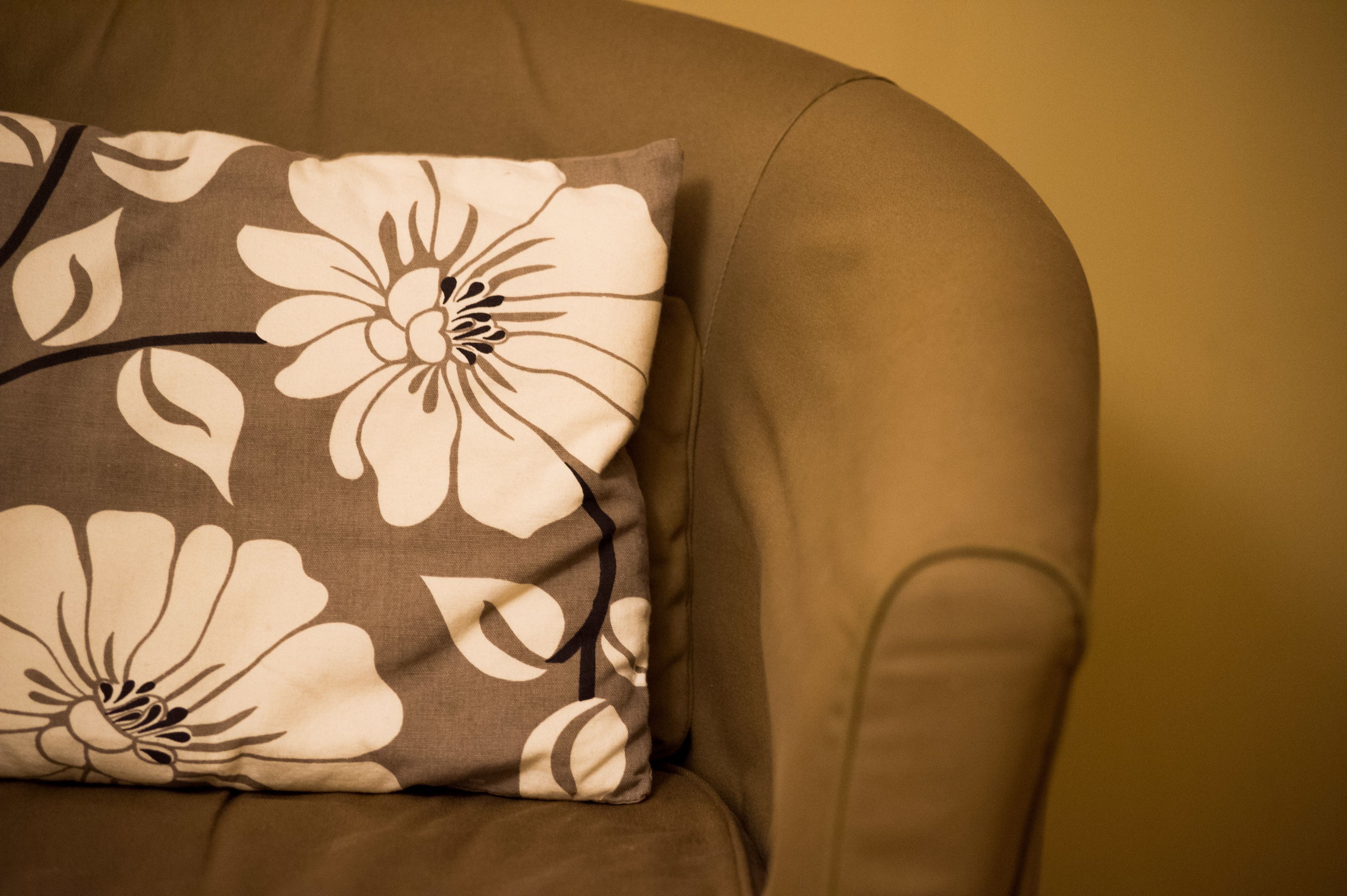 Ein Sofa im Detail mit einem floralen Kissen.