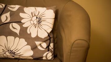Ein Sofa im Detail mit einem floralen Kissen.