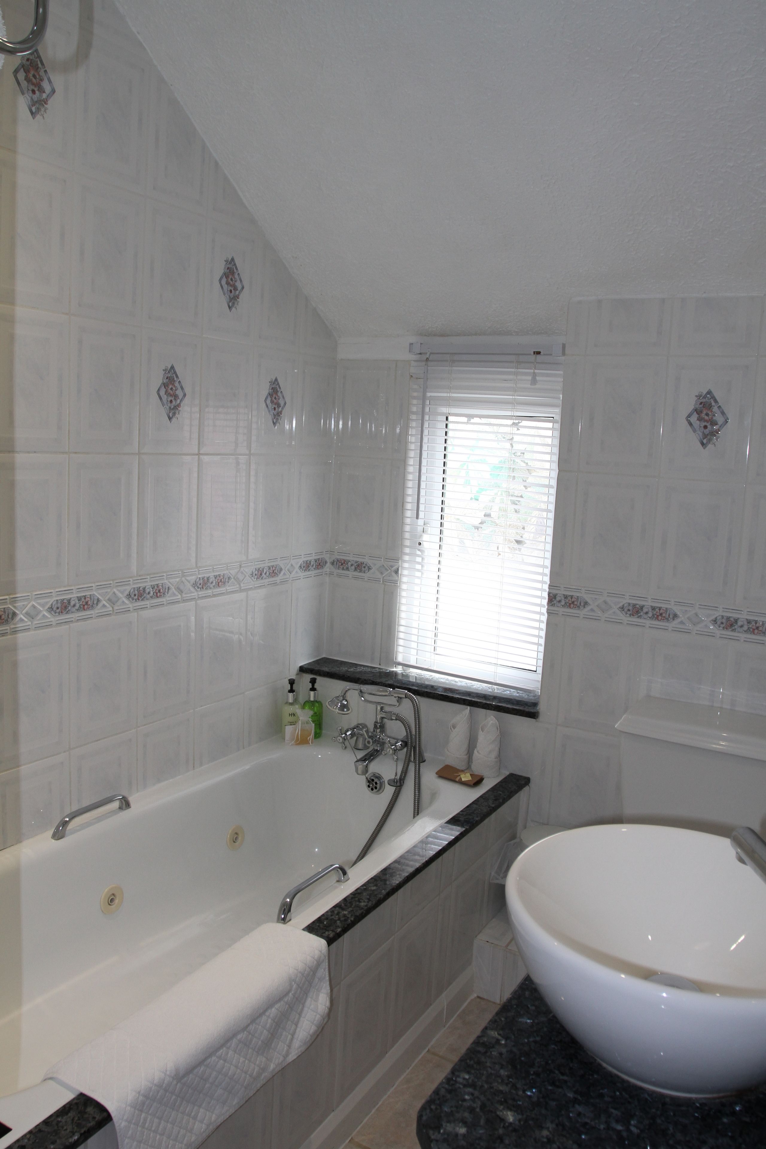 A bathroom with a bathtub, a sink, and a window.