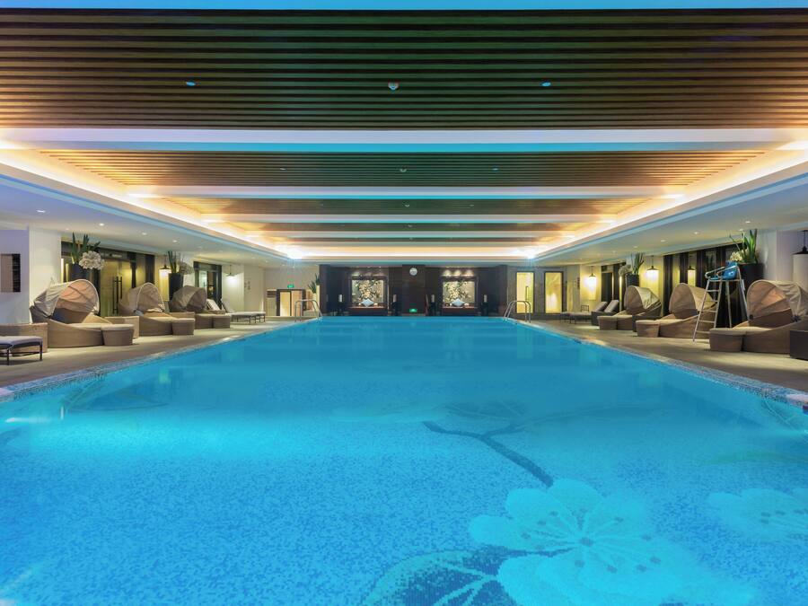 Una piscina cubierta, una piscina al aire libre de temporada, tumbonas