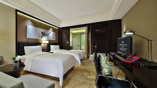 A hotel room with a bed, a desk, a TV, and a lamp. - Crowne Plaza Chengdu Panda Garden by IHG - Near Panda Base (Chengdu)