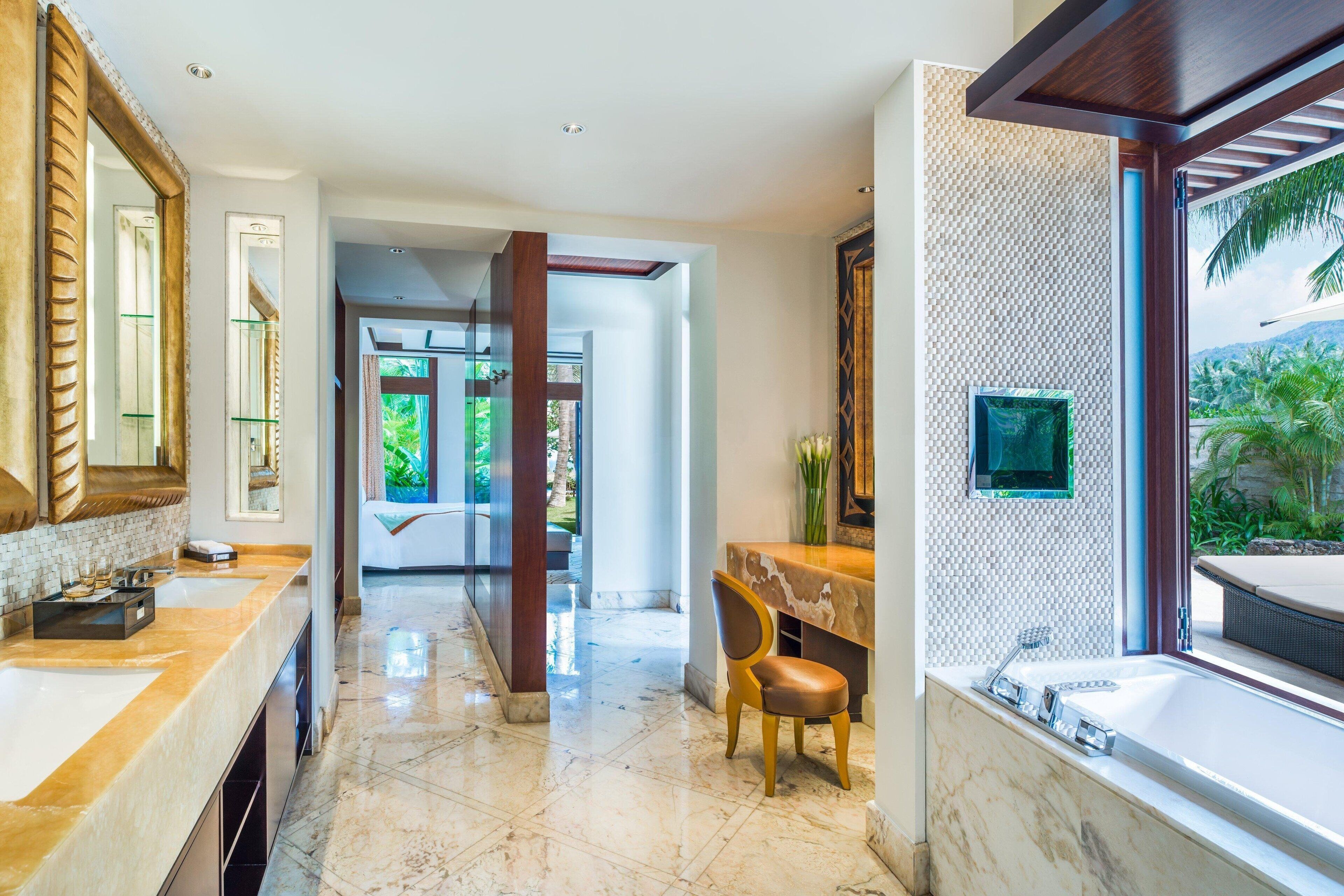 A modern bathroom with a large mirror, a bathtub, and a vanity with a sink.