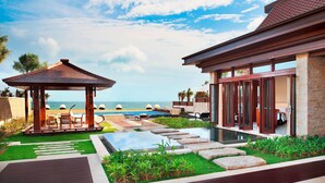 Un resort con piscina, un pabellón y vista al océano.