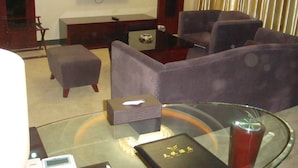 A modern living room with a flat-screen TV, comfortable seating, a glass coffee table, and a small side table. - Guangzhou Tianyue Hotel (Guangzhou)