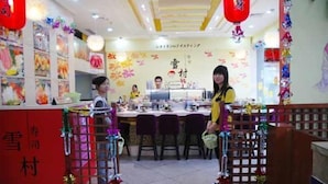 A restaurant interior with a counter, chairs, and decorative elements. - Guangzhou Tianyue Hotel (Guangzhou)