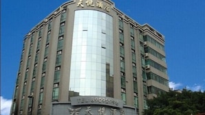A multi-story hotel with a modern architectural design, featuring a prominent glass facade and a series of balconies. - Guangzhou Tianyue Hotel (Guangzhou)