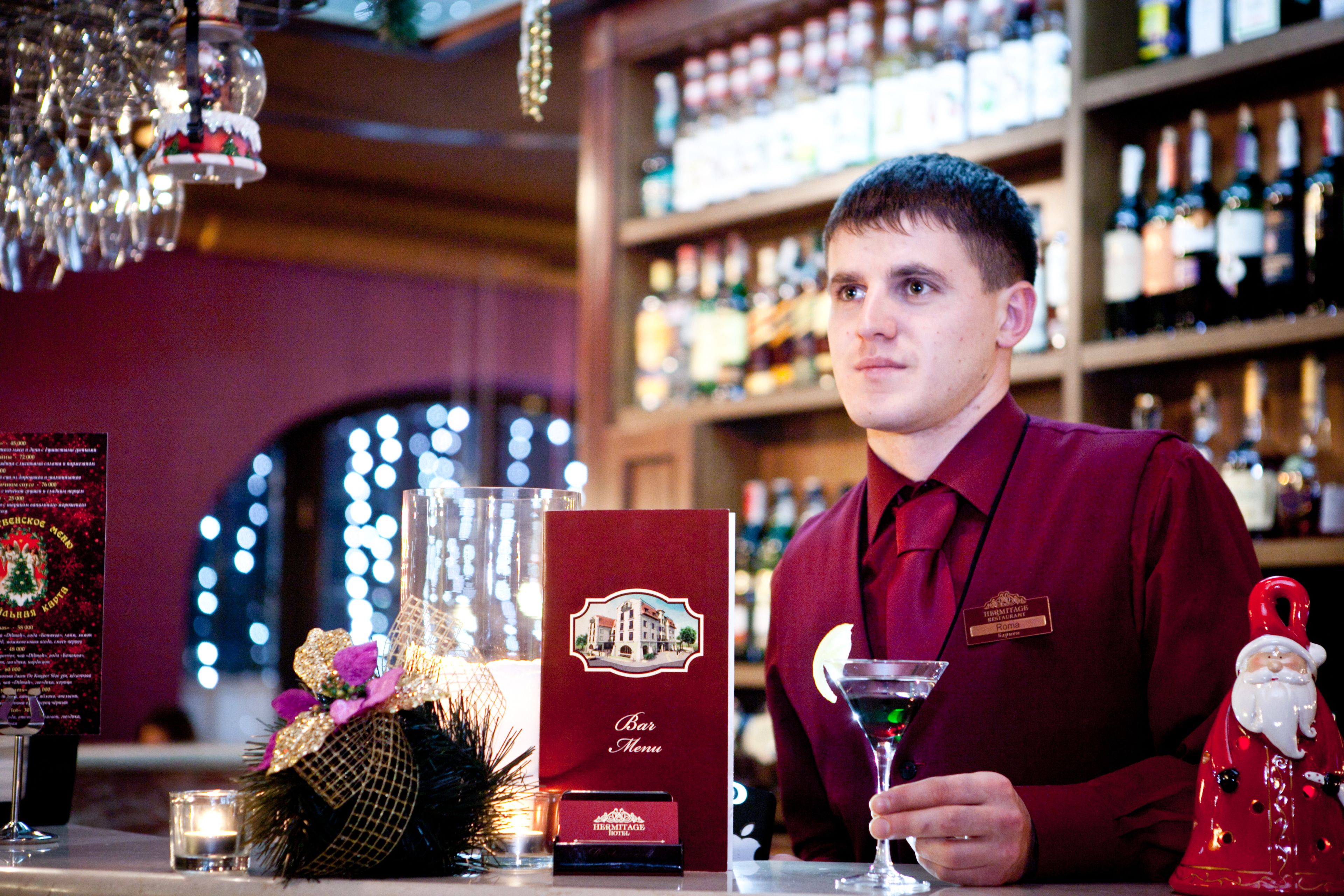 Een barsetting met een bartender, een menukaart en feestelijke decoratie.