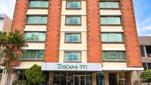 A multi-story building with a sign reading "Toscana Inn." - Toscana Inn (Panama City)