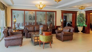 A spacious living room with leather sofas, a coffee table, and decorative lamps. - Toscana Inn (Panama City)