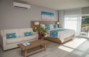 A hotel room with a bed, a sofa, a coffee table, and a window with curtains.