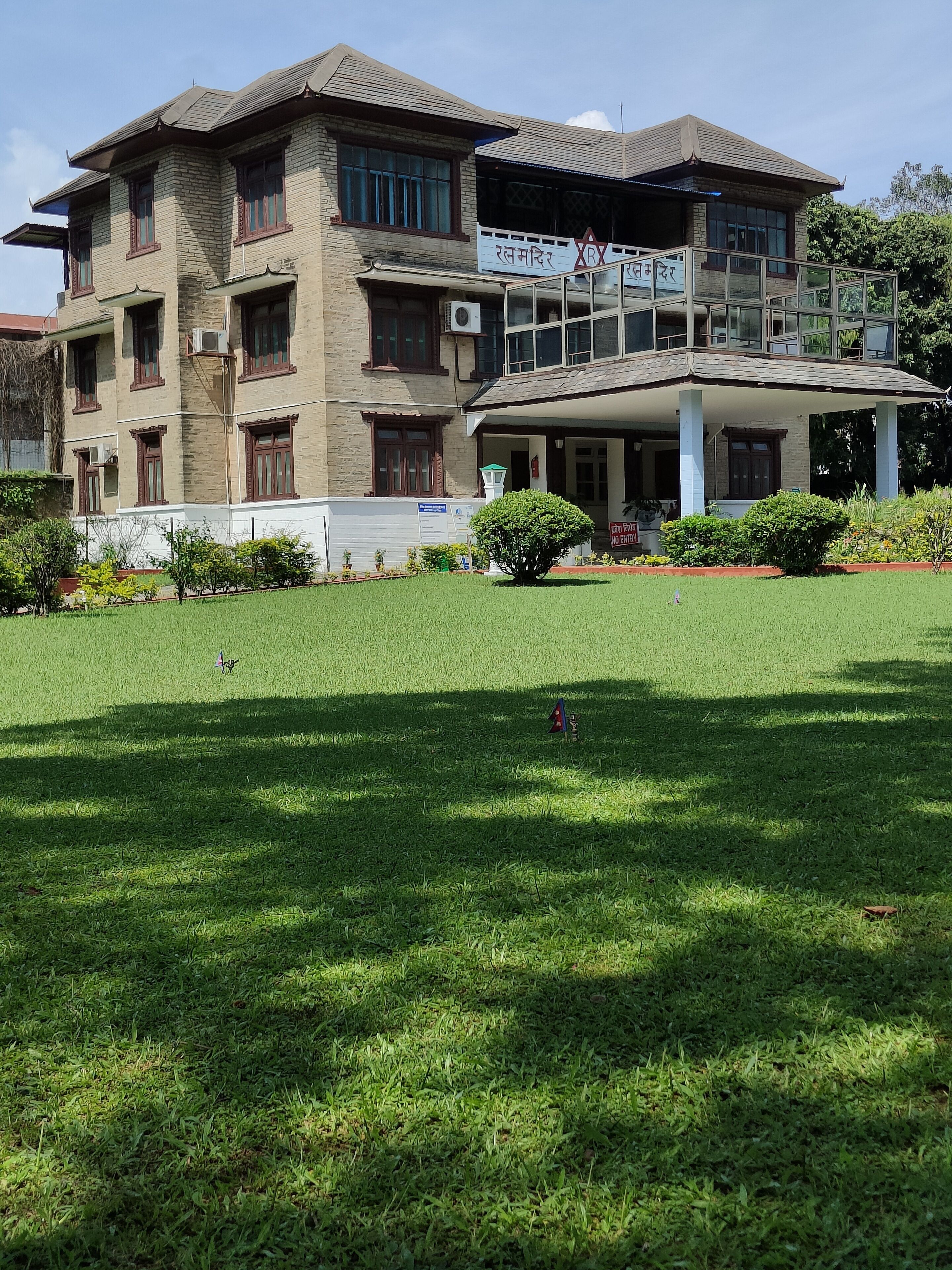 A multi-story building with a flat roof and a covered entrance area.