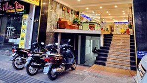 The exterior of the Golden Lotus hotel with a visible entrance, a staircase leading to the entrance, and parked motorcycles outside. - Golden Lotus Hotel (Nha Trang)