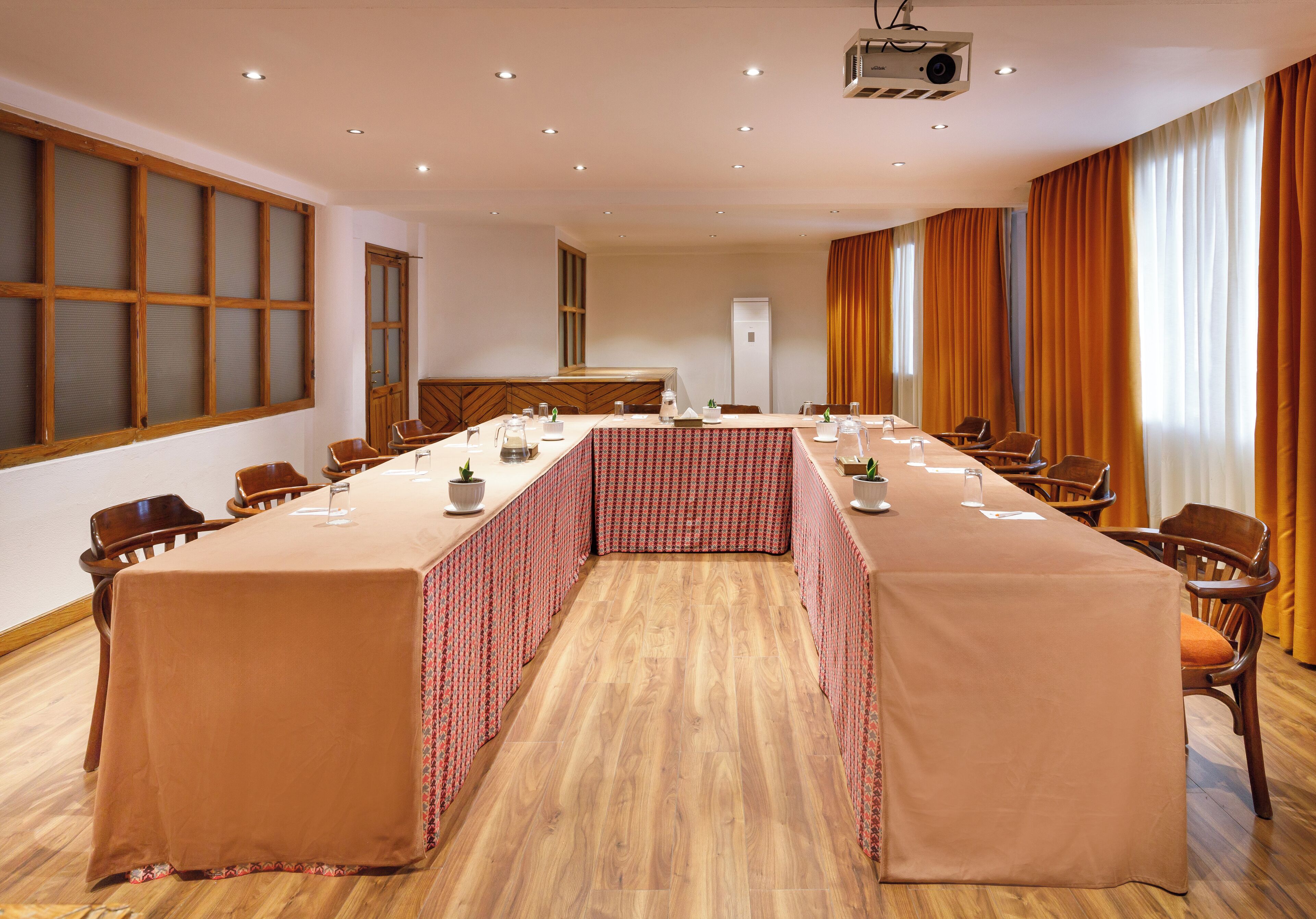Une salle de conférence équipée d’une longue table, de chaises et d’un projecteur.