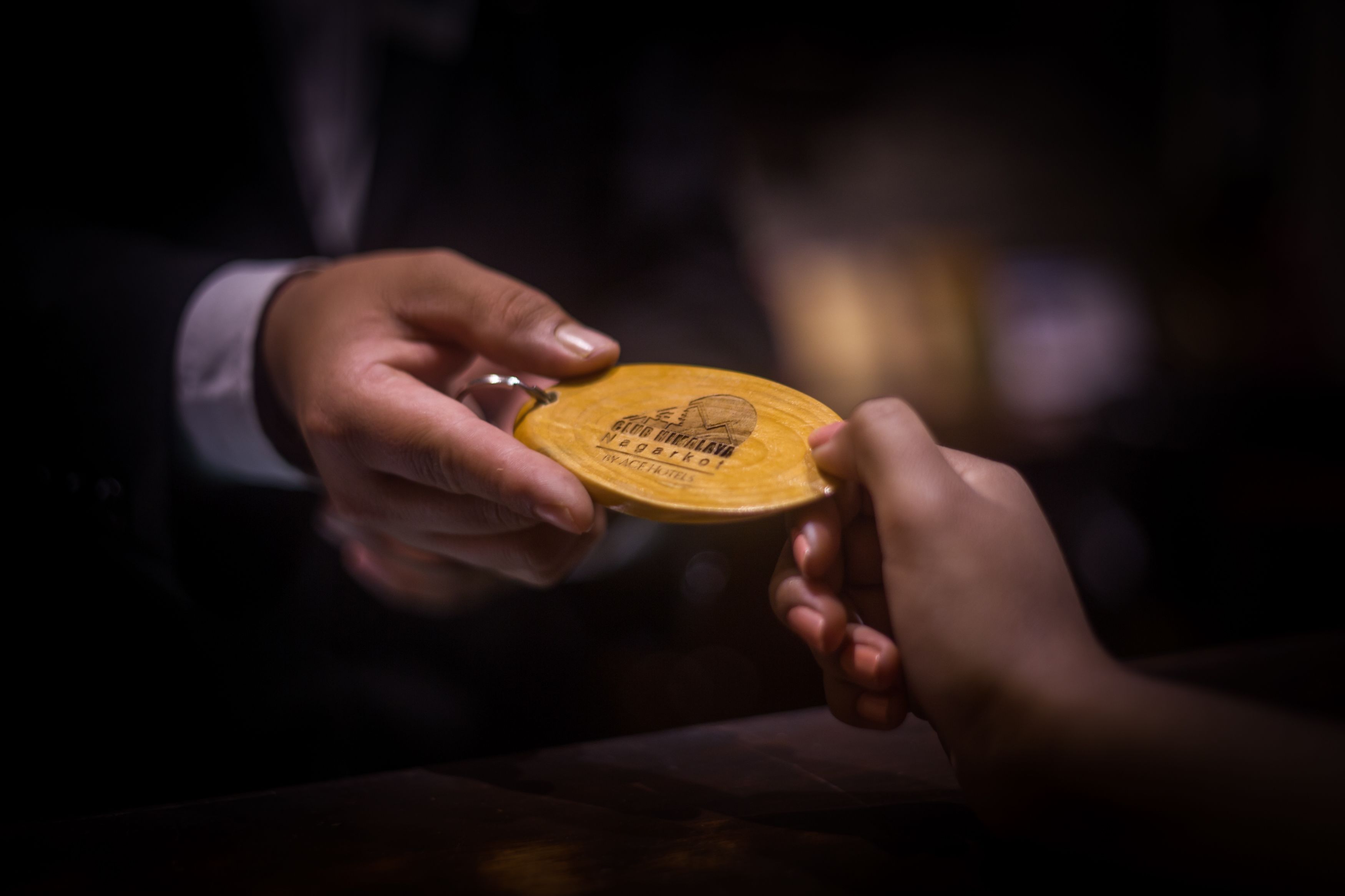 A person holding a wooden plaque with engraved text.