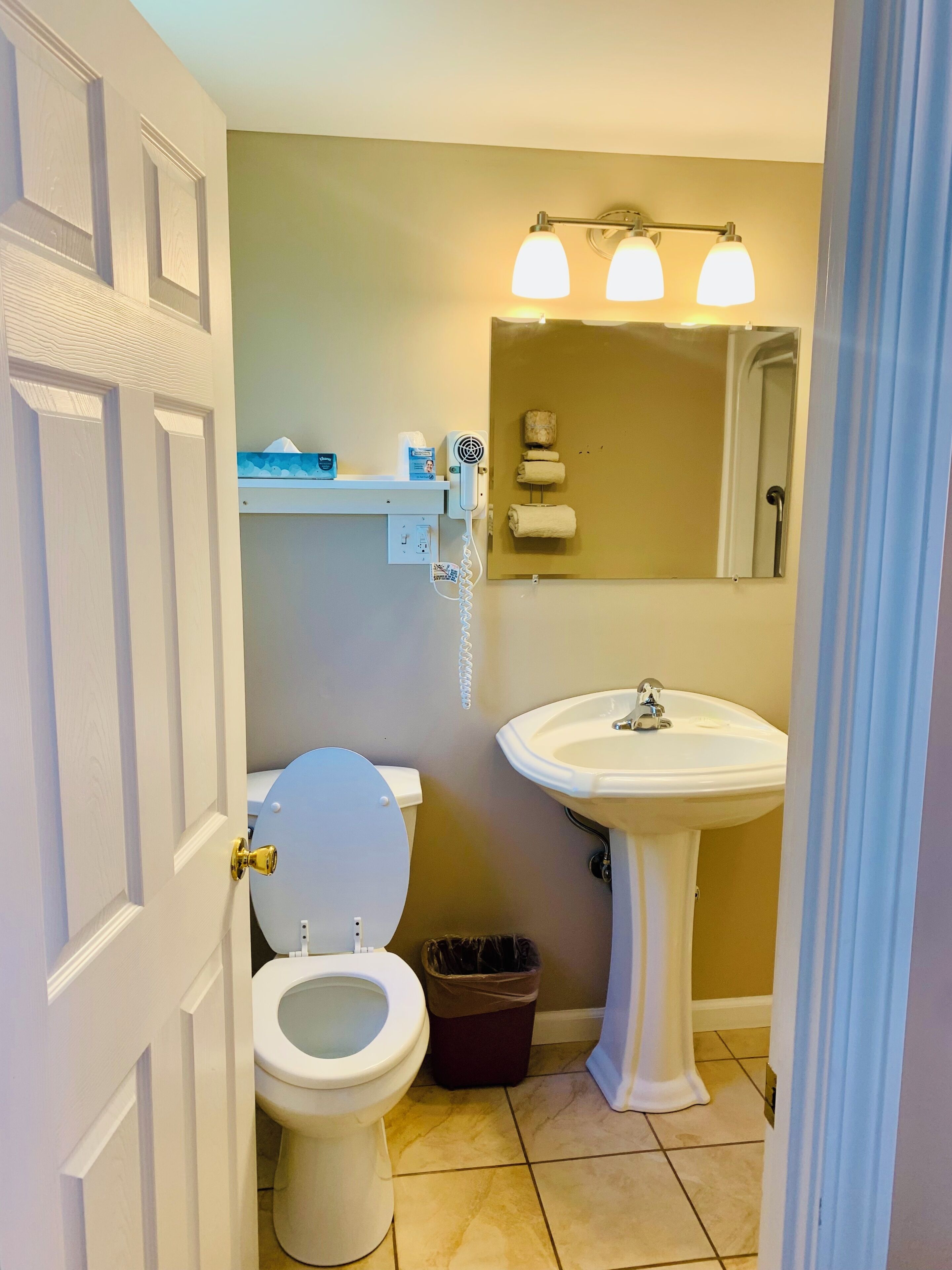 A bathroom with a toilet, sink, and towel rack.