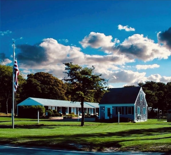 A building with a blue roof, a white steeple, and a flagpole with an American flag.