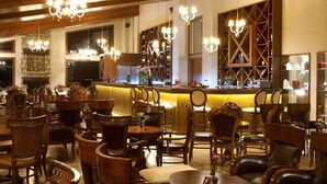 Un restaurante con barra, sillas de madera y candelabros.