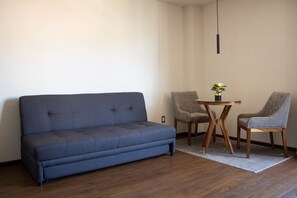 Studiosuite – junior, byutsikt | Oppholdsområde | En 50-tommers Flatskjerm-TV med kabel-kanaler samt TV