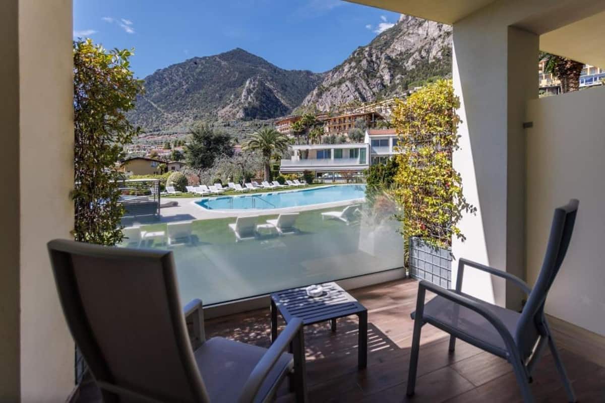A balcony with a view of a pool and mountains.
