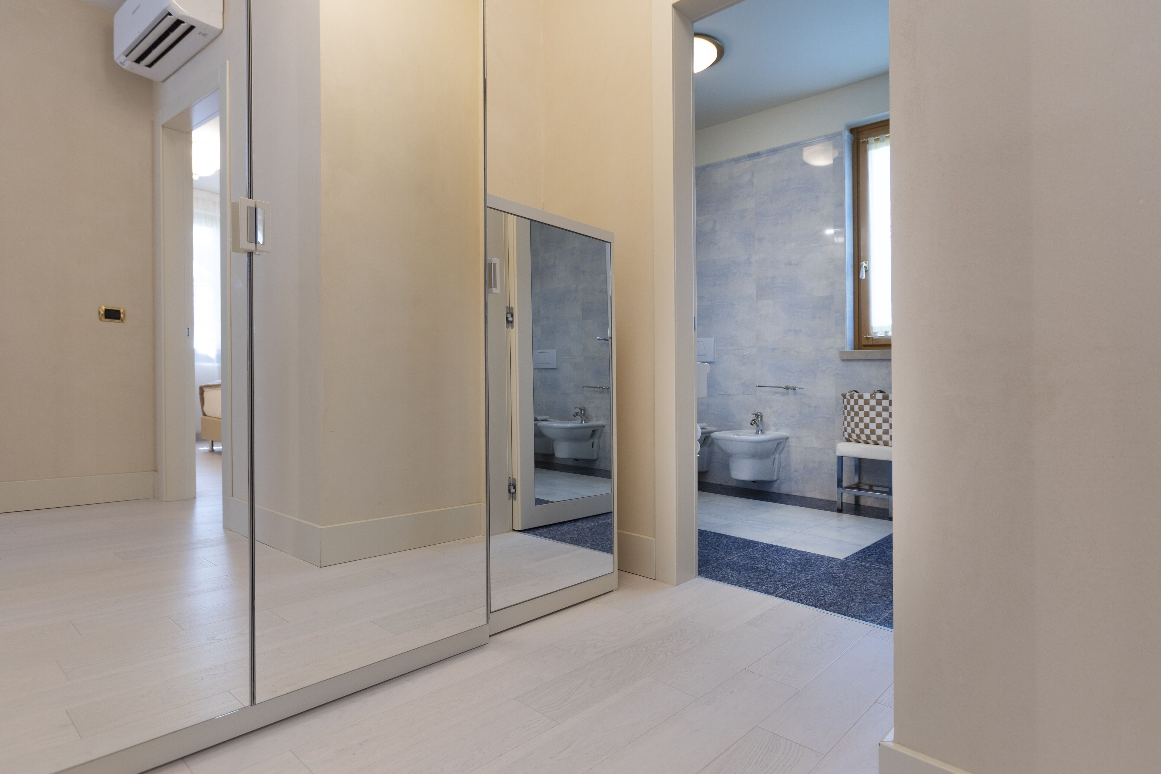 A modern bathroom with a glass partition, a sink, and a mirror.