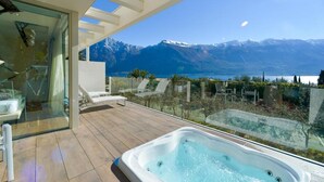 A balcony with a hot tub, lounge chairs, and a glass wall offering a mountain view. - Park Hotel Imperial Centro Tao Natural Medical Spa (Limone sul Garda)