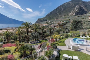 Un complexe hôtelier doté d’une piscine, de palmiers et offrant une vue sur un paysage montagneux.
