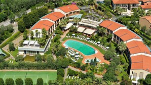 An aerial view of a resort with multiple buildings, a swimming pool, and a tennis court. - Park Hotel Imperial Centro Tao Natural Medical Spa (Limone sul Garda)