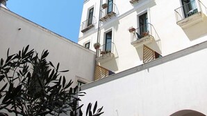 Un edificio de varios pisos con balcones y ventanas, visto a través de un arco.
