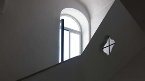 Una escalera con diseño curvo que lleva a un rellano con ventana.