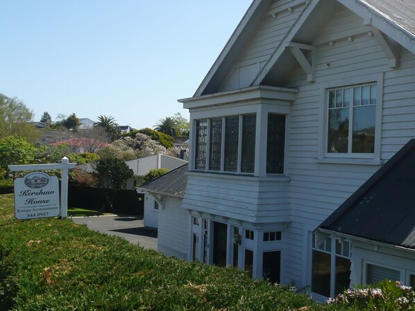 A white two-story house with a prominent bay window and a sign indicating it is a boutique accommodation. - Kershaw House Boutique Accommodation (Richmond)