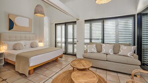 A bedroom with a bed, bedside table, and a sofa. - Julians Apartments (Byron Bay)