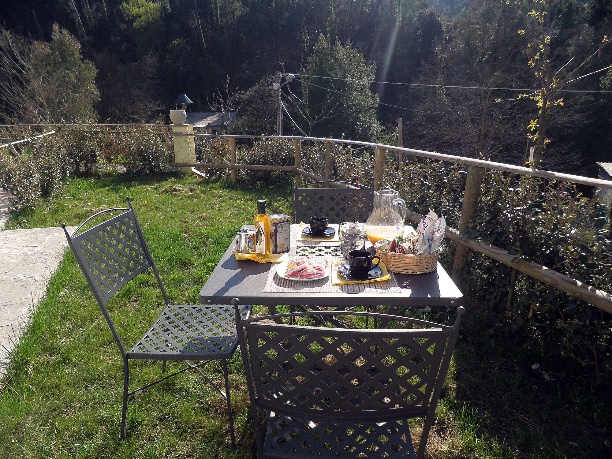Un espace de restauration en plein air comprenant une table, des chaises et divers plats et boissons.