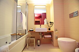 A modern bathroom with a bathtub, sink, and toilet.