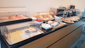 A buffet area with various food items and a coffee machine. - Cosmopolitan Hotel (Civitanova Marche)
