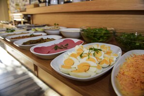 A buffet table with various dishes including sliced eggs, salads, and other prepared foods. - Taya Hatun Hotel (Istanbul)