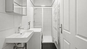 A modern bathroom with two sinks, a shower, and a towel rack. - AJO Vienna Messe - Contactless Check-in (Vienna)