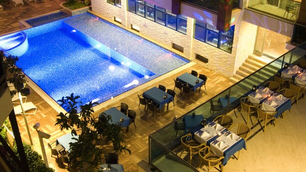An indoor swimming pool with adjacent dining area and lounge chairs. - Supreme Marmaris Hotel (Marmaris)