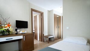 A hotel room with a bed, a desk with a TV, a small table, and a chair. - Supreme Marmaris Hotel (Marmaris)