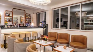 Eine Bar mit Sitzgelegenheiten, einem großen Spiegel und einer Kristallleuchter.