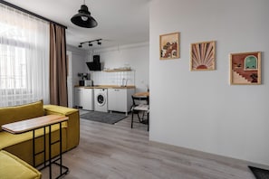 Un apartamento moderno con comedor, cocina y sala de estar con sofá y mesa.