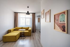 Una sala de estar moderna con un sofá, una mesita y una lámpara de techo.