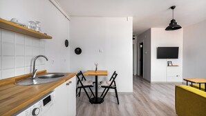 Et moderne køkken med træbordplade, indbygget vask og spiseplads med bord og stole.