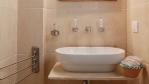 A bathroom with a white sink, a mirror above it, and a towel rack to the left. - Masseria Pelosella B&B (Fasano)