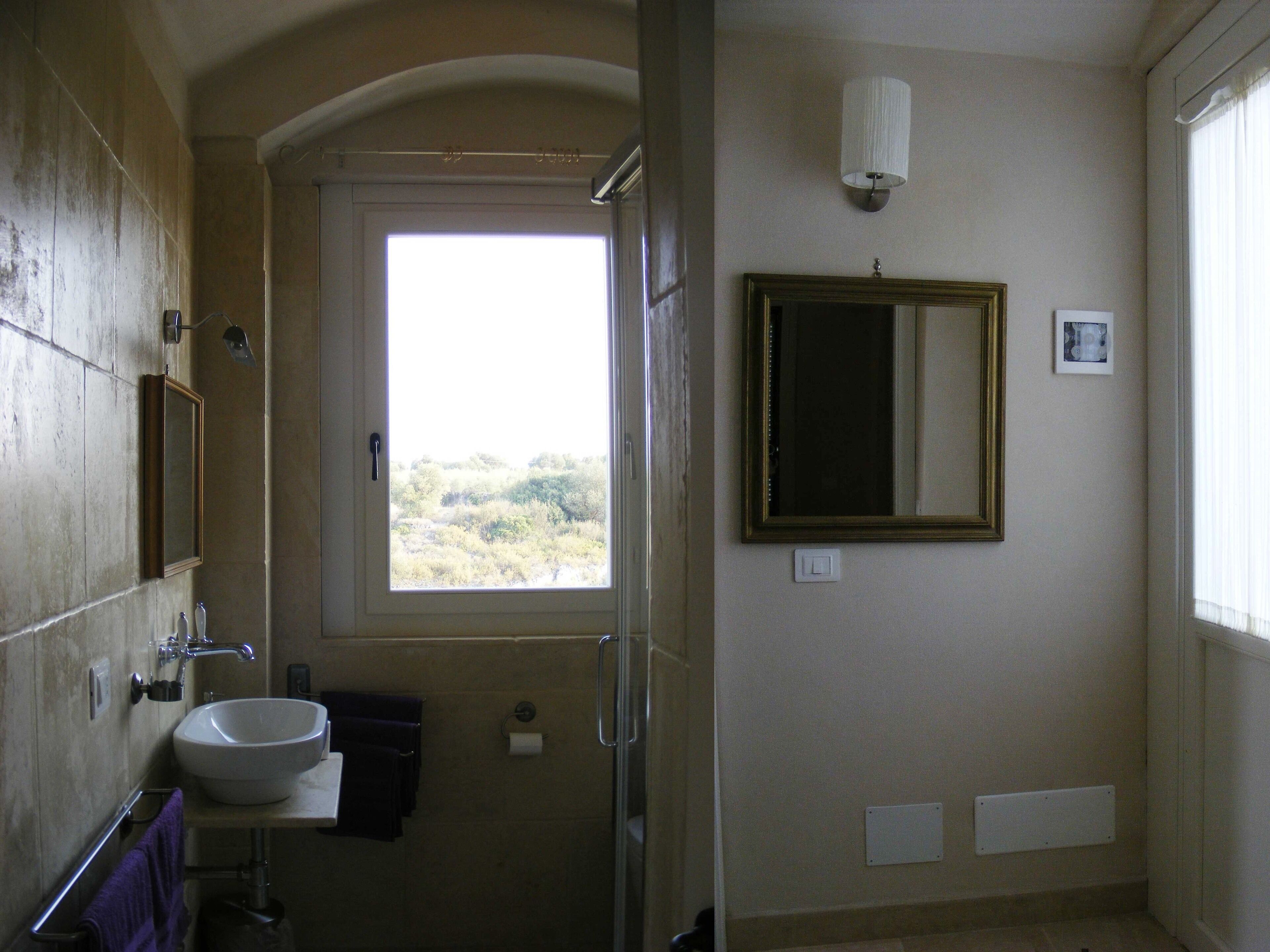 Un bagno con lavandino, specchio e finestra.
