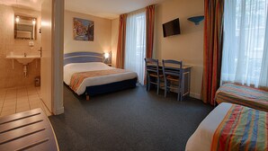 A hotel room with a bed, a desk, a chair, a TV, and a bathroom. - Le Ruisseau (Saint-Mandé)