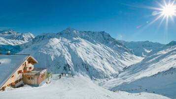 A snow-covered mountain with a wooden building on the left.